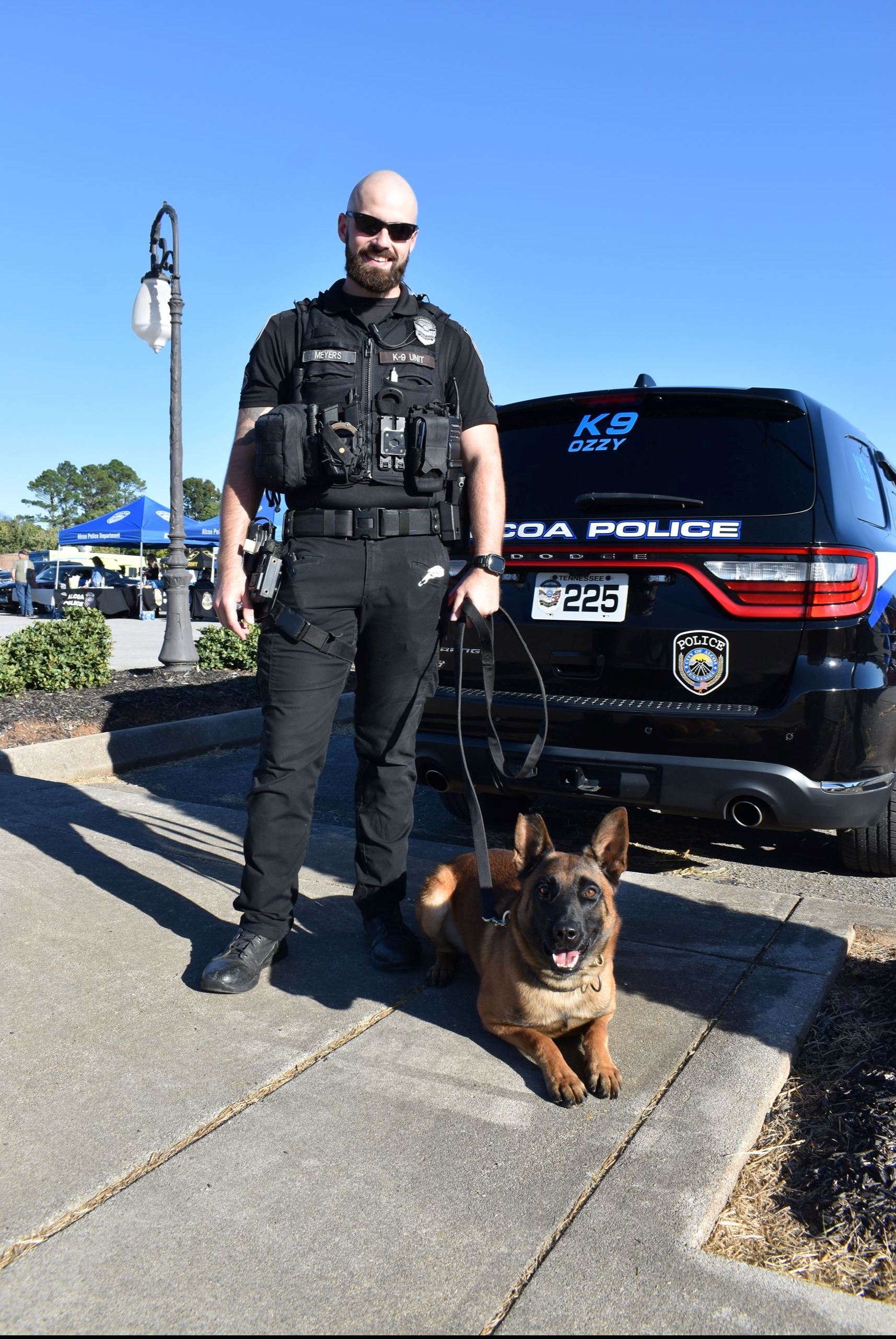 Officer Meyers with k9 Ozzy in front of police cruiser